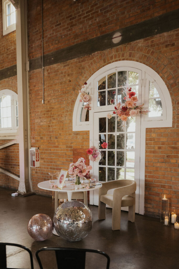 Sweetheart table with disco balls and pink flowers at BRICK