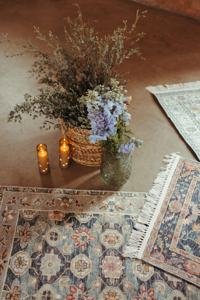 Wedding ceremony details with rugs and florals