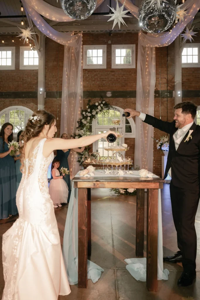 Bride and groom pouring champagne into a coupe tower