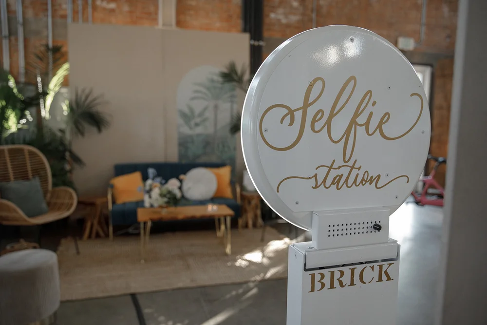 BRICK's selfie station set up for a holiday office party with a lounge area as the backdrop