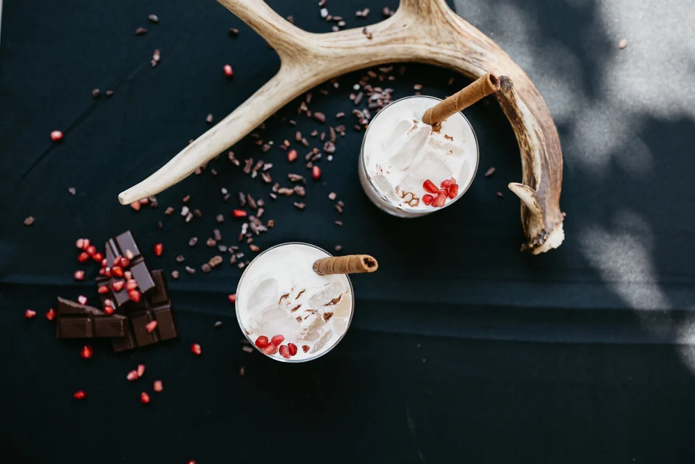 Winter cocktail with white foam and fruit and chocolate garnish