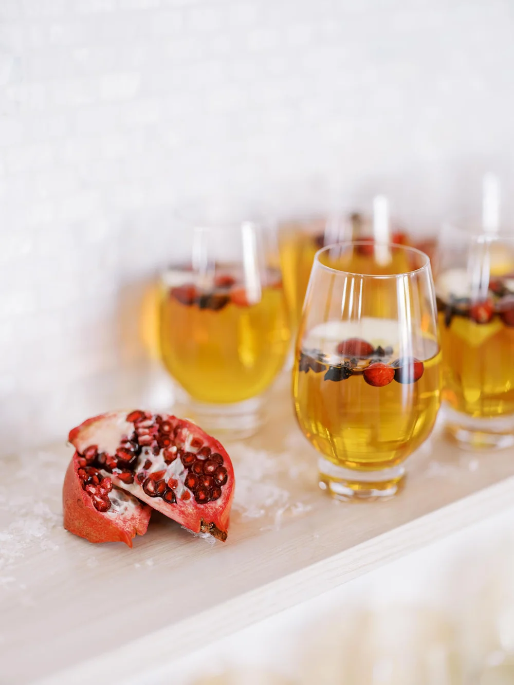 Wintery cocktails in wine glasses with pomegranate garnish