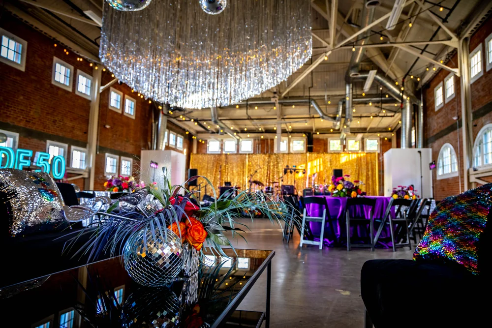 BRICK San Diego office holiday party set up with 70s theme, colorful tinsel, and retro décor.