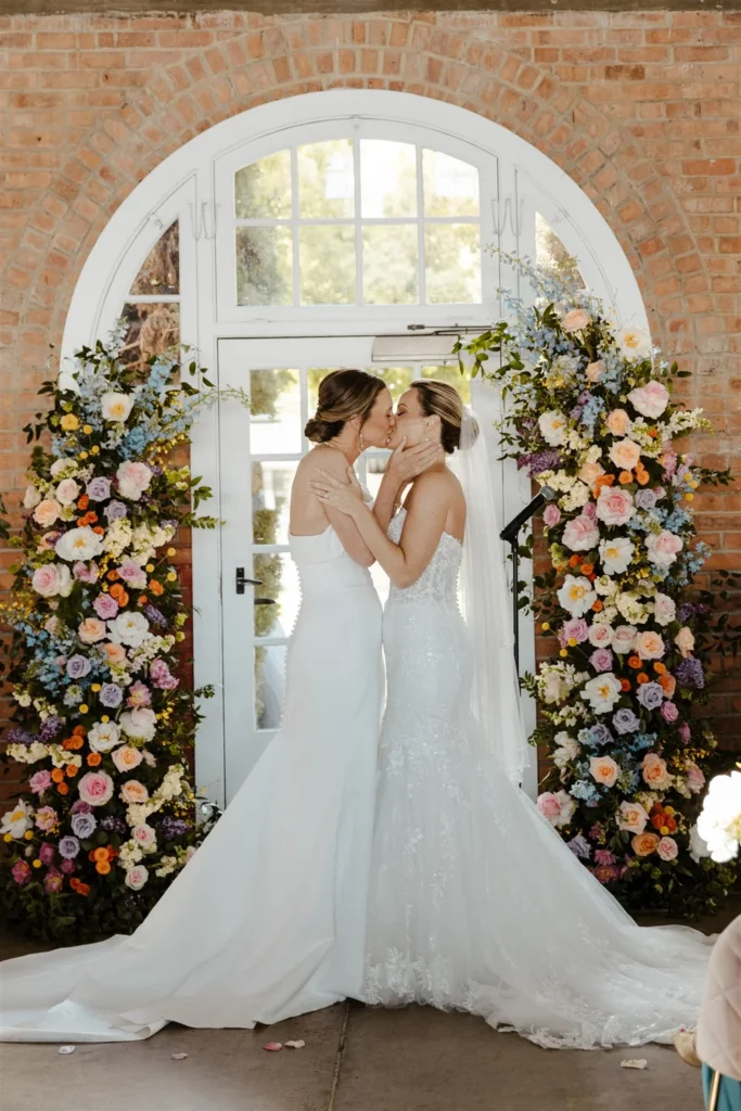 Two brides kissing at the altar during their wedding at BRICK in San Diego, CA