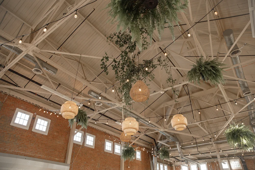 Greenery hanging from the ceiling with rattan light fixtures at BRICK San Diego event venue