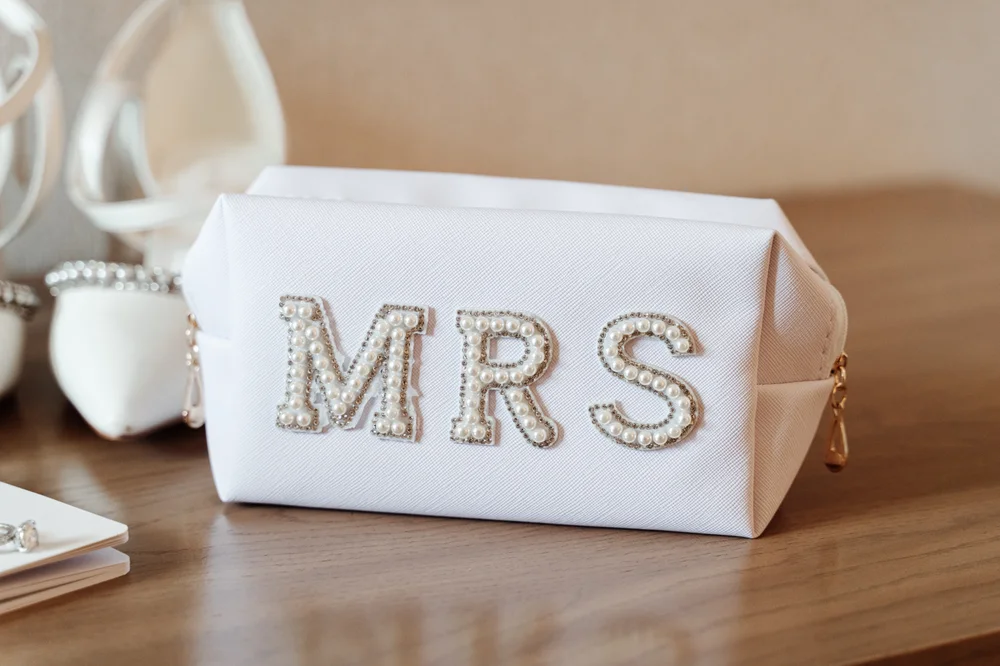 Bridal makeup bag with “MRS” beaded letters, perfect for wedding day prep and newly engaged inspiration