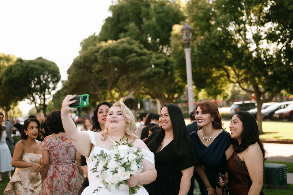 Bride taking a selfie with her wedding guests outside of BRICK in San Diego, CA