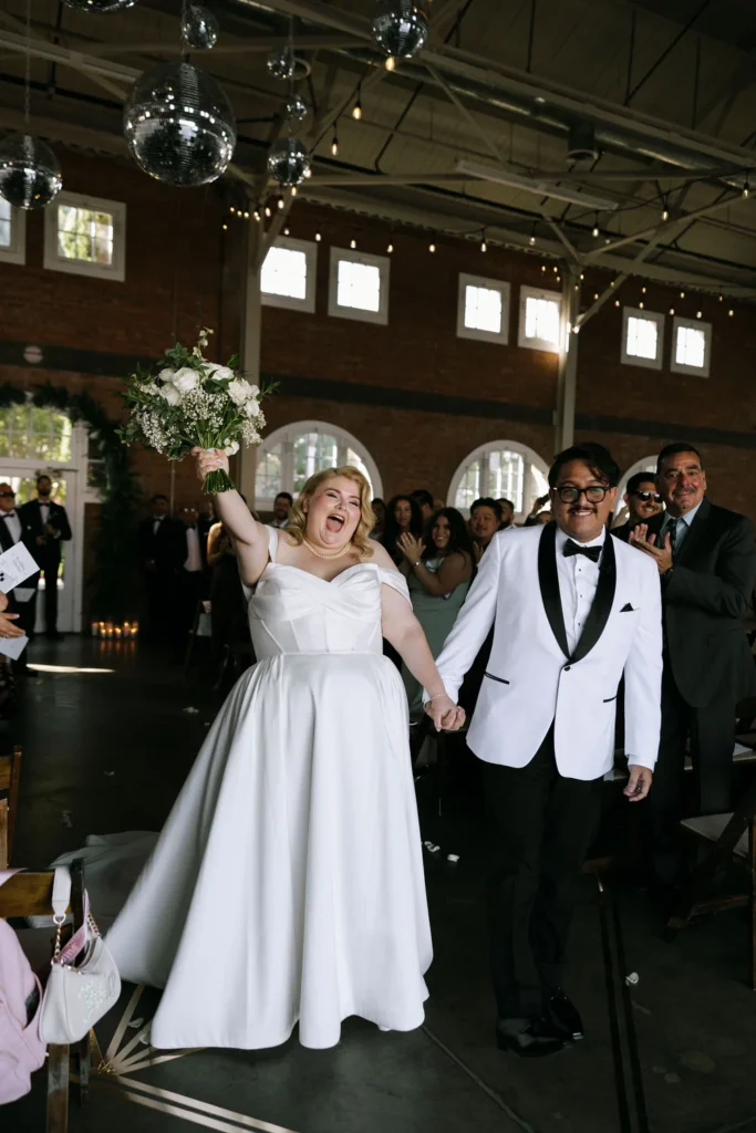 Bride and groom walking down the aisle at their BRICK San Diego wedding, celebrating their marriage with guests in attendance