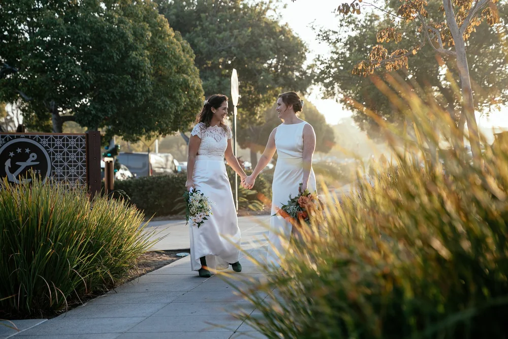 LGBTQ+ brides holding hands outside BRICK wedding venue in San Diego CA