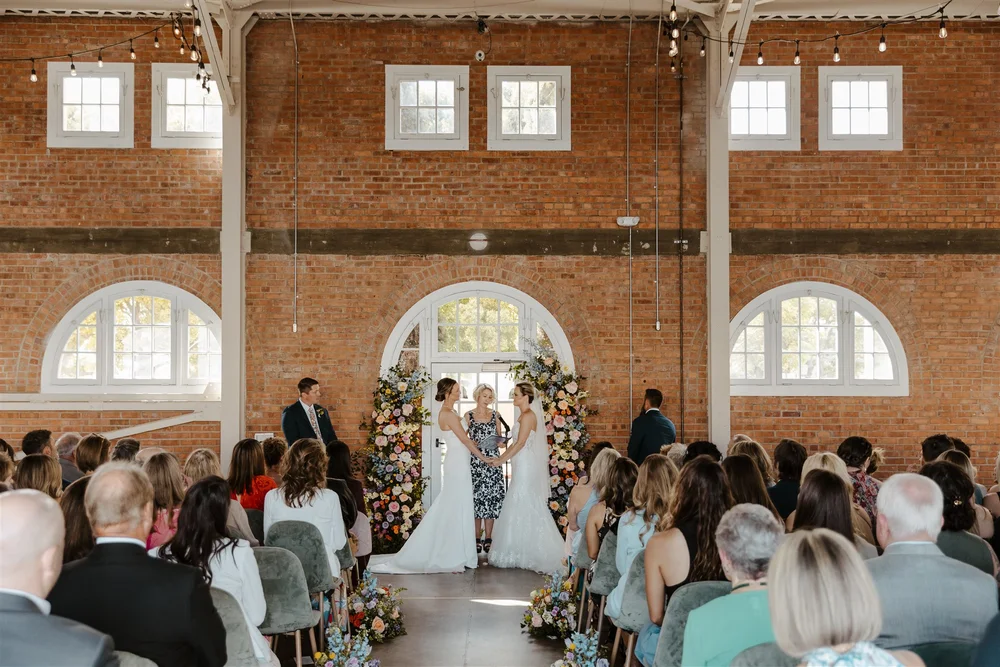 LGBTQ+ brides saying their wedding vows at BRICK venue in San Diego CA